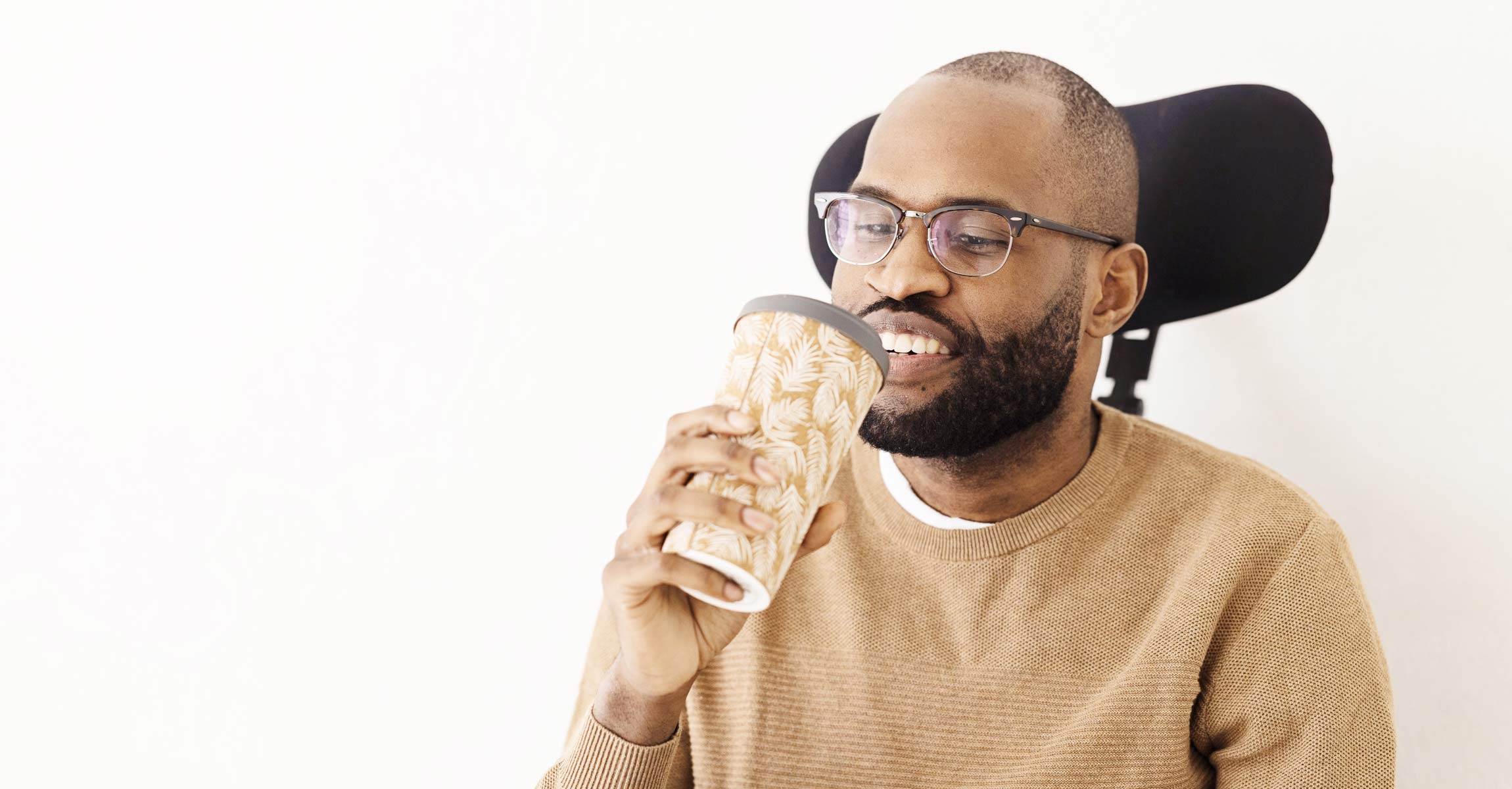 man drinking from feather patterned cup