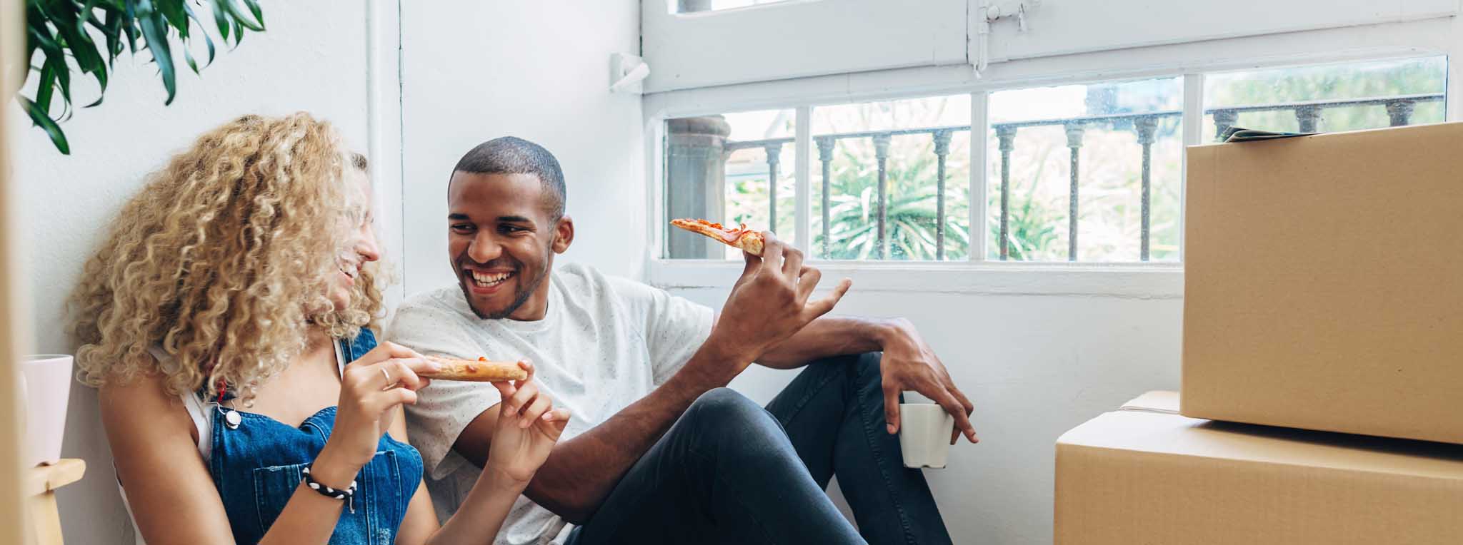 couple sat with boxes eating pizza