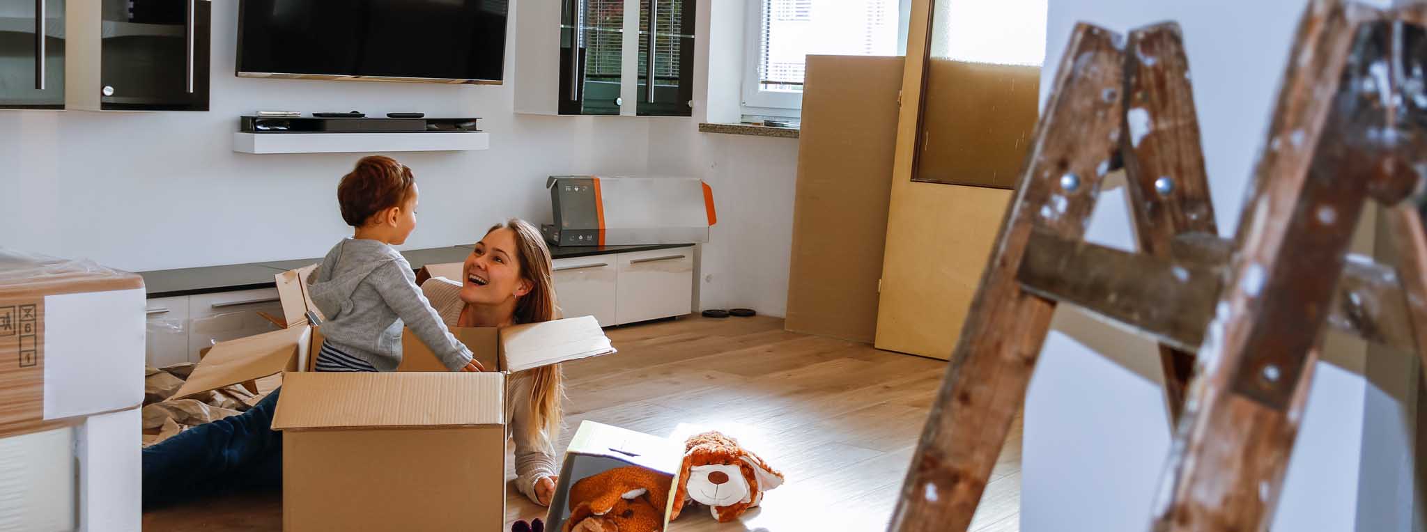 Boy playing in box with parent