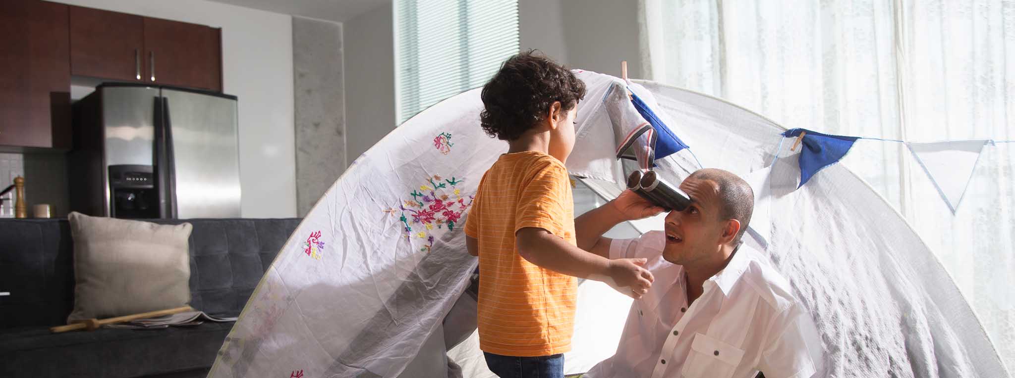 Man and boy in tent in living room