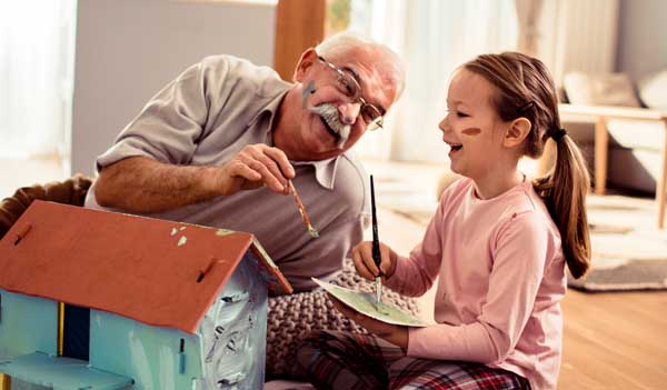 Grandfather and grandchild playing with house