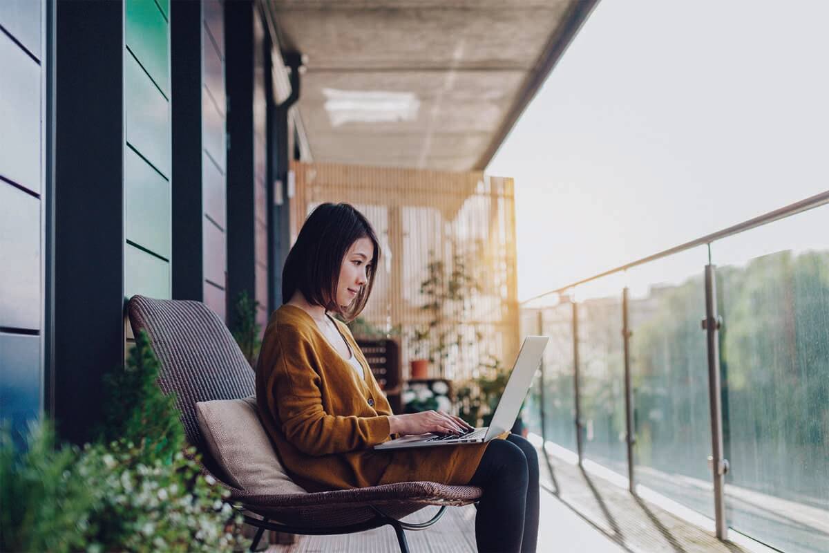 Woman outside looking at laptop