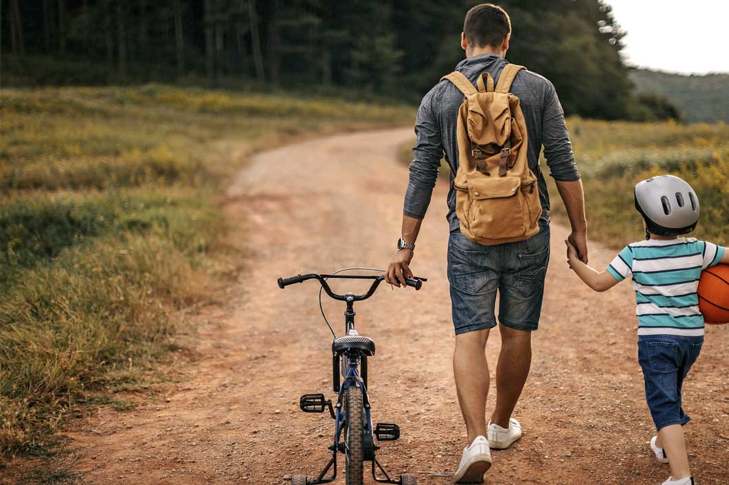 Father and son walking with bike